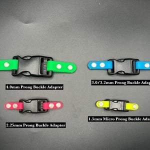 May include: Four different types of buckle adapters for straps. The adapters are color-coded and labeled with their prong size: 4.0mm, 3.0/3.2mm, 2.25mm, and 1.5mm Micro.