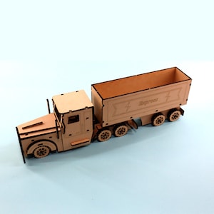 Op de afbeelding: Een houten model van een vrachtwagen met een aanhanger. De aanhanger is gelabeld "Express" met een bliksem-afbeelding. Het model is gemaakt van bruin hout en heeft zwarte lijnen.