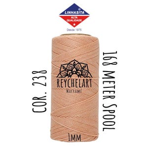 May include: A spool of 1 mm thick peach-coloured cord, labelled "168 Meter Spool", "COR. 238", and "REYCHELART MACRAMÉ". The spool is wrapped in a label with the text "LINHASITA ALTA QUALIDADE" and "Desde 1975".