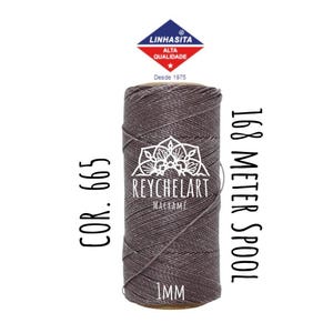 Może przedstawiać: Szpula sznurka szarego o grubości 1 mm, oznaczona "COR. 665" i "168 Meter Spool". Szpula jest owinięta etykietą z tekstem "REYCHELART MACRAMÉ" i logo.