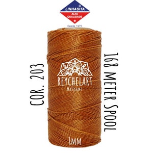 Könnte beinhalten: Eine Spule braunen Fadens mit dem Text "COR. 203" links und "168 METER SPOOL" rechts. Die Spule ist mit "REYCHELART" beschriftet und hat eine Dicke von 1 mm.