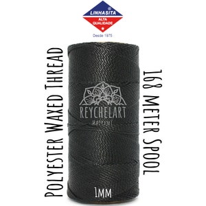 Könnte beinhalten: Eine Spule mit 168 Metern schwarzem, gewachstem Polyesterfaden, 1 mm dick. Die Spule ist mit "Polyester Waxed Thread 168 Meter Spool 1mm" beschriftet und trägt ein Logo mit der Aufschrift "ReycheLart Handmade".