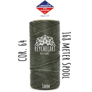 Könnte beinhalten: Eine Spule mit 1 mm dickem grünem Garn mit dem Aufdruck "COR. 64" und "168 METER SPOOL" auf der Seite. Die Spule ist mit "REYCHELART MACRAME" beschriftet.