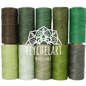 May include: Ten spools of green and brown cotton cord, arranged in a gradient from dark brown to light green. The spools are labelled "REYCHELART MACRAMÉ".