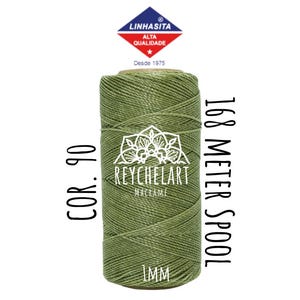 Pode incluir: Uma bobina de cordão de macramé verde de 1 mm com o texto "COR. 90" à esquerda e "168 METER SPOOL" à direita. A bobina é etiquetada "REYCHELART MACRAME" e tem um pequeno rótulo que diz "LINHASITA ALTA QUALIDADE Desde 1975".