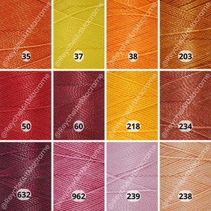 May include: Twelve spools of embroidery floss in various colors, including orange, yellow, red, brown, pink, and peach. The spools are labeled with numbers: 35, 37, 38, 50, 60, 218, 234, 632, 962, 239, 238, and 203.