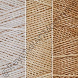 May include: Three skeins of yarn in different shades of beige. The skeins are made of a soft, natural fiber and are perfect for knitting or crocheting.