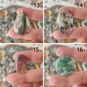 Op de afbeelding: Vier gepolijste edelsteen cabochons in verschillende vormen: druppel, ovaal en rond. De stenen vertonen een mix van kleuren, waaronder groen, wit, roze en bruin, met natuurlijke patronen. Elke steen wordt tussen de vingers gehouden.