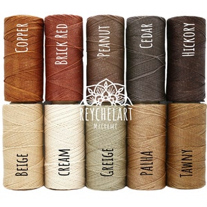 May include: Ten spools of cotton cord in various shades of brown, beige, and cream. The spools are labeled with the color names: Copper, Brick Red, Peanut, Cedar, Hickory, Beige, Cream, Greige, Palha, Tawny.
