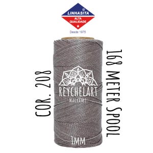 Puede incluir: Una bobina de cordón de macramé gris de 1 mm de grosor. La bobina está etiquetada con "168 Meter Spool" y "Cor. 208". La etiqueta también incluye el nombre de la marca "ReycheLart Macrame".