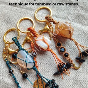 Op de afbeelding: Drie macram&eacute; sleutelhangers met ingekapselde stenen. Elke sleutelhanger heeft een andere steen, waaronder een witte agaat, een lichtbruine steen en een heldere steen. De sleutelhangers zijn gemaakt van bruin, oranje en groen macram&eacute; koord en hebben zwarte kralen en gouden accenten.