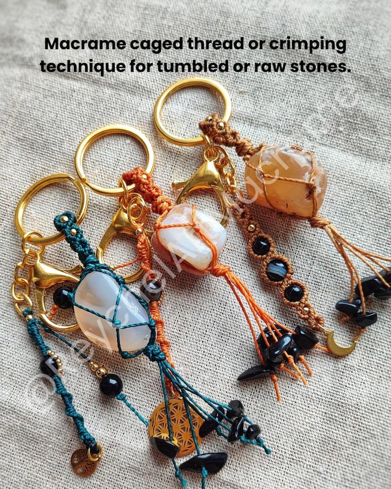 Op de afbeelding: Drie macram&eacute; sleutelhangers met ingekapselde stenen. Elke sleutelhanger heeft een andere steen, waaronder een witte agaat, een lichtbruine steen en een heldere steen. De sleutelhangers zijn gemaakt van bruin, oranje en groen macram&eacute; koord en hebben zwarte kralen en gouden accenten.
