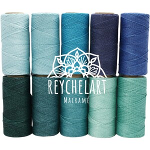 Może przedstawiać: Dziesięć szpul bawełnianego sznurka w różnych odcieniach niebieskiego i zielonego. Sznurek idealnie nadaje się do projektów makramy.