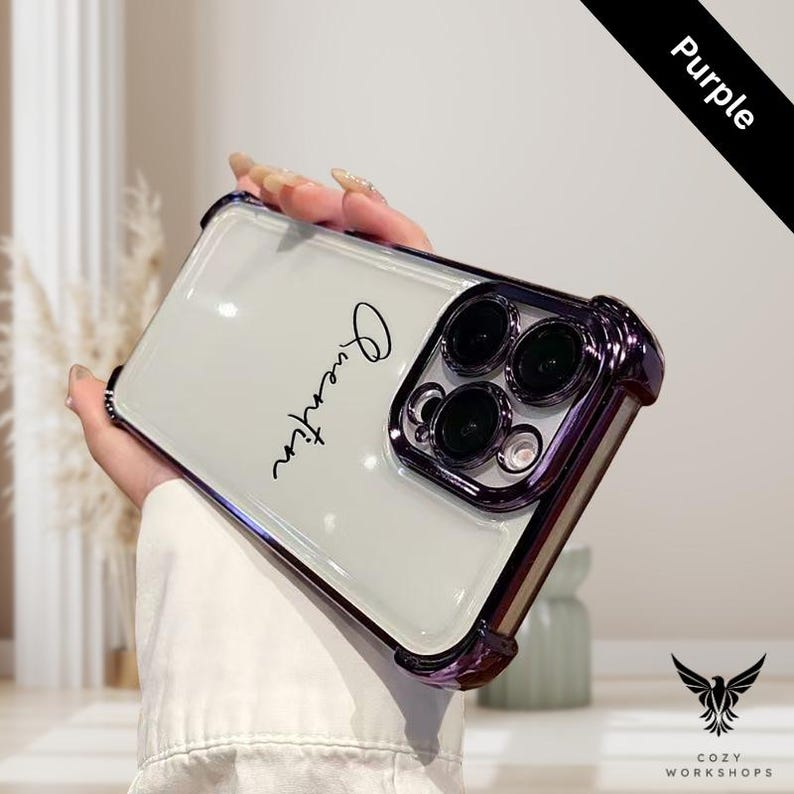 May include: A clear phone case with a purple metallic bumper and the name "Quentin" in black script. The case has a clear back and a protective design around the camera lenses. The word "Purple" is on a black diagonal banner.