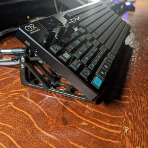 May include: A black keyboard with blue keys and a black stand. The keyboard has the text "OX MIDI" on the side.