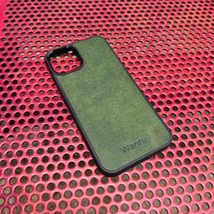 May include: A green phone case with a black border and the word "Wanru" printed on the back.