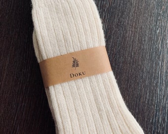 May include: A pair of white ribbed socks with a brown label that says "DOKU" and a small leaf design.