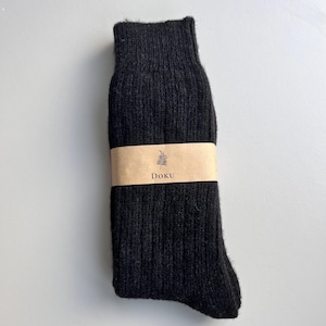 May include: Black wool socks with a brown label that says "Doku" and a small leaf design.