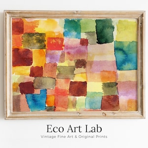 May include: A framed abstract watercolor painting with a geometric pattern of squares in various shades of red, orange, yellow, green, blue, and purple. The painting is in a light wood frame.