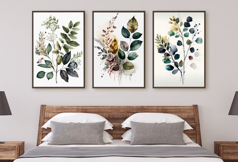 May include: Three framed watercolor paintings of leafy branches with green, blue, and yellow leaves. The paintings are hung on a white wall above a wooden headboard.