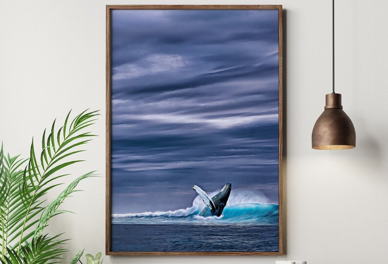 May include: A framed print depicts a whale breaching the ocean's surface. The artwork features a dark blue sky with dramatic cloud formations. The whale's tail is visible above a turquoise wave, creating a dynamic ocean scene.