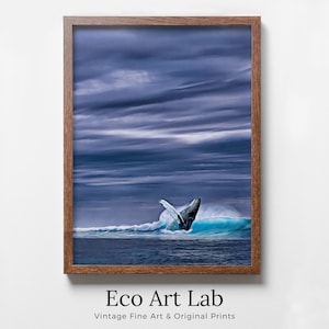 May include: A framed print featuring a breaching whale in a turquoise wave under a dramatic, cloudy sky. The artwork is set in a brown wooden frame. The text "Eco Art Lab" and "Vintage Fine Art & Original Prints" are at the bottom.