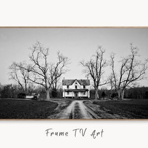 May include: A black and white photograph of an abandoned house with a long driveway leading up to it. The house is surrounded by bare trees and the sky is overcast.