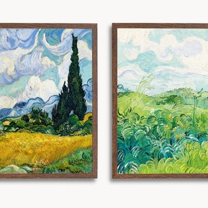 May include: Two framed paintings of landscapes by Vincent van Gogh. The first painting shows a field of wheat with a tall cypress tree in the background. The second painting shows a field of green grass with a blue sky in the background.