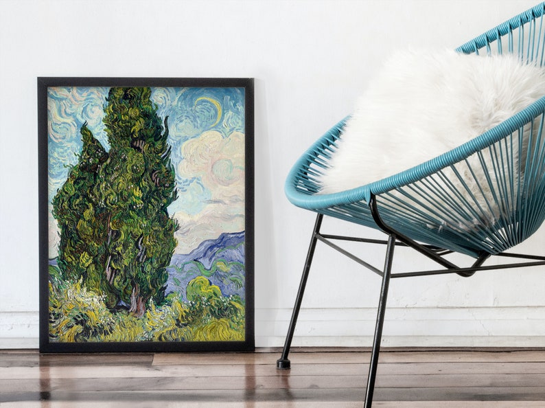 May include: A framed painting of two tall, green cypress trees against a blue and white sky with a crescent moon. The painting is in a black frame and is hanging on a white wall.