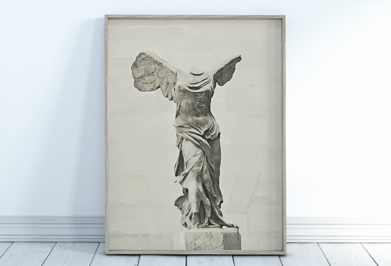 May include: A black and white photograph of the Winged Victory of Samothrace statue, a famous ancient Greek sculpture. The statue is displayed in a frame.