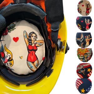 May include: Yellow safety helmet with a custom interior liner featuring a vintage tattoo design. The liner displays a woman in a red swimsuit, a heart, a rose, and a swallow bird. Additional liners with various designs are also shown.