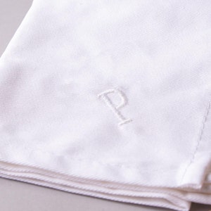 May include: White linen napkin with a single initial "P" embroidered in the center.