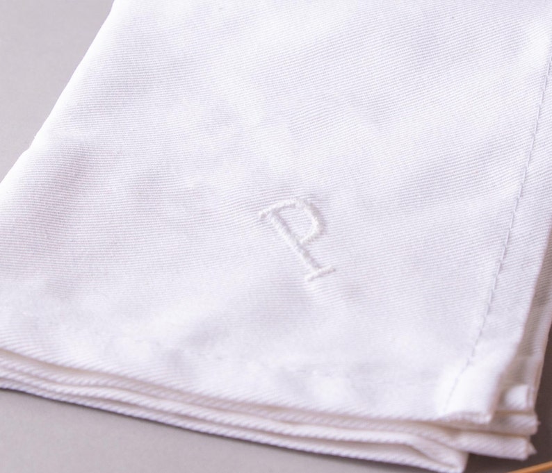 May include: White linen napkin with a single initial "P" embroidered in the center.