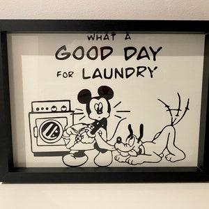 Puede incluir: Ilustración en blanco y negro de Mickey Mouse y Pluto lavando la ropa. El texto dice "Qué buen día para lavar la ropa".