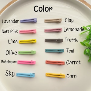 May include: Color chart showing ten different colors of hair clips. The colors are lavender, soft pink, lime, olive, bubblegum, sky, clay, lemonade, truffle, teal, carrot, and corn.