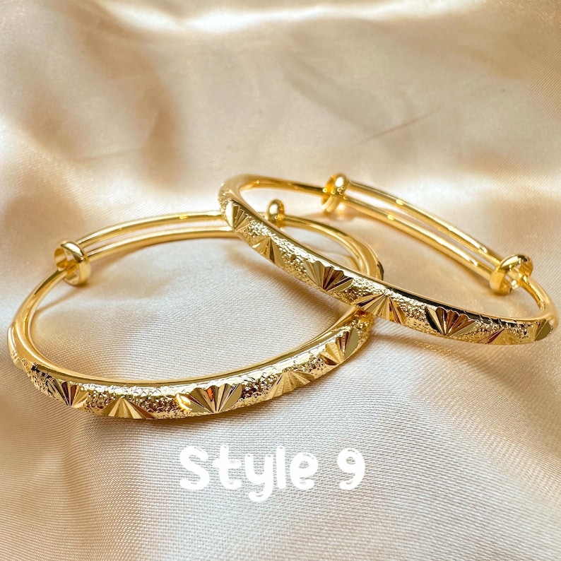 May include: Two gold-colored adjustable bangles with a textured geometric pattern. The bangles are displayed on a satin surface. The text "Style 9" is visible in white at the bottom of the image.