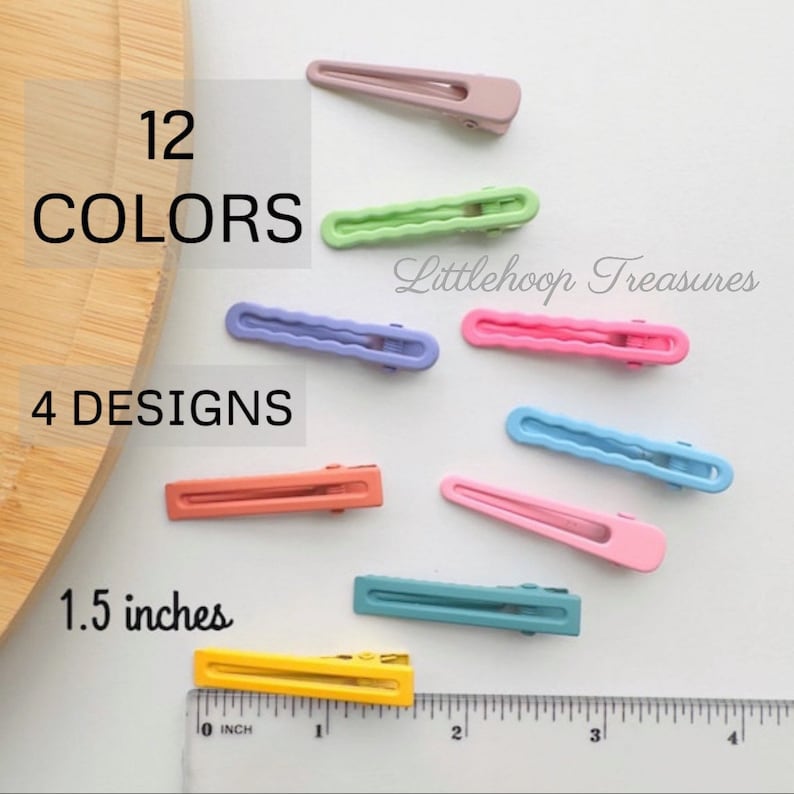 May include: Twelve colorful hair clips in four different designs. The clips are 1.5 inches long and are arranged on a white surface. The text "Littlehoop Treasures" is visible in the image.