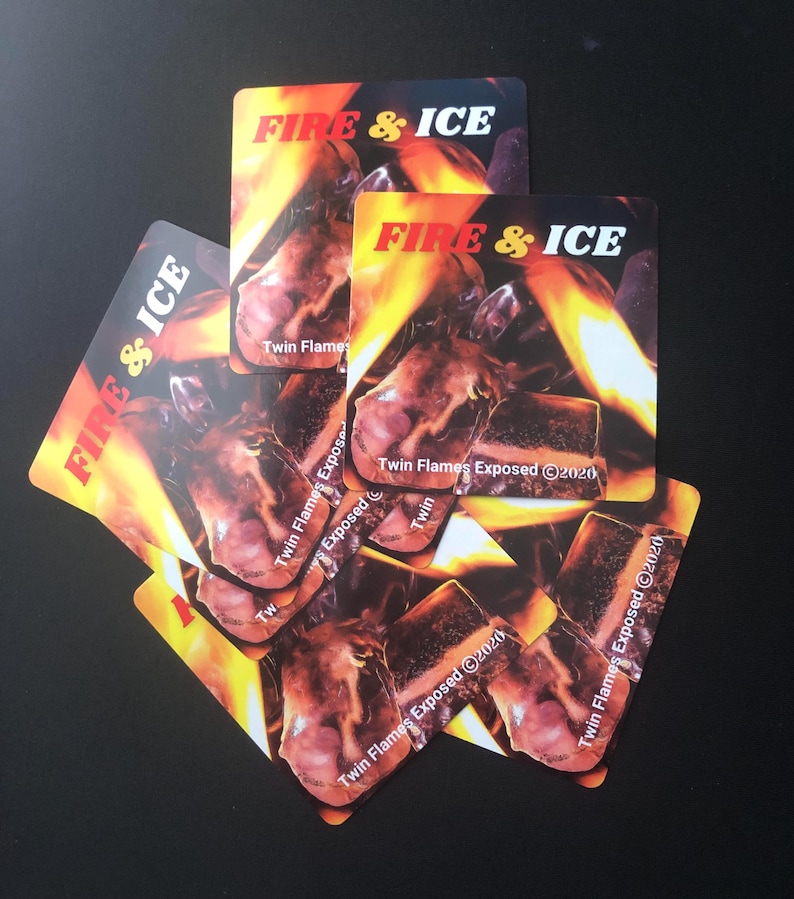 Pu&ograve; includere: Un mucchio di cinque adesivi quadrati con il testo "FIRE & ICE" e le parole "Twin Flames Exposed 2020" stampate su di essi. Gli adesivi presentano uno sfondo arancione e giallo fuoco con un'immagine ravvicinata del viso di una persona.