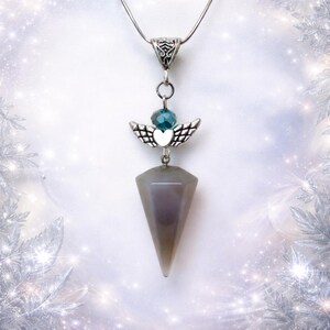 May include: A silver pendant necklace with a grey, faceted pendulum. The pendulum hangs below a small angel charm with silver wings, a blue bead, and a heart. The necklace has a fine silver chain.