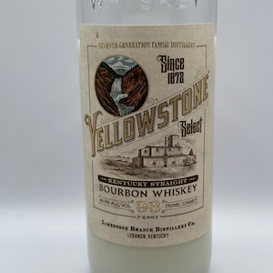 May include: A clear glass bottle with a label that reads "Yellowstone Select Kentucky Straight Bourbon Whiskey" with a waterfall and a distillery illustration. The label also states "Since 1872", "46.5% Alc/Vol", "93 Proof", and "750ml (LF4687)". The label also states "Limestone Branch Distillery Co. Lebanon, Kentucky".