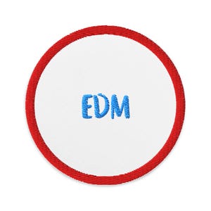May include: A red and white round embroidered patch with the word "EDM" in blue lettering.