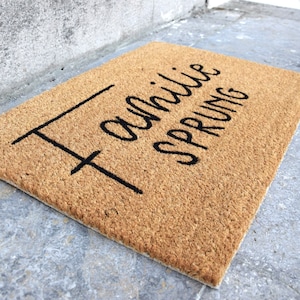 May include: A brown coir doormat with the text "Family is everything" written in black cursive.