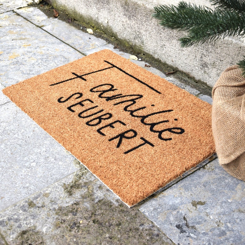 May include: A brown coir doormat with the text "Familie Seibert" in black cursive lettering.