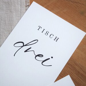May include: White sign with black text that reads "Tisch frei" which translates to "Table free" in English.