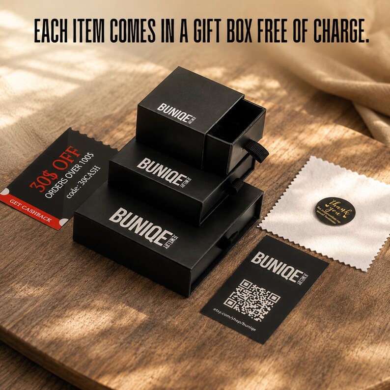 May include: Three stacked black square jewelry boxes with the white text BUNIQE JEWELRY. Includes a black card with a QR code, a black discount card with 30% OFF text, a small white square polishing cloth, and a round black thank you sticker.