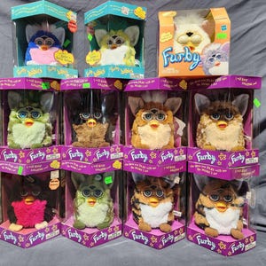 Collection of 11 Furby electronic toys by Tiger Electronics including 2 furby babies all are new in original boxes