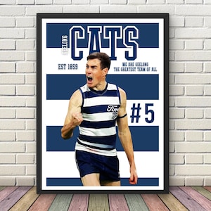 Può includere: Un poster incorniciato con un giocatore dei Geelong Cats in uniforme a righe blu e bianche, che celebra una vittoria. Il poster include il testo "CATS", "GEELONG", "EST 1859" e "#5". Lo sfondo presenta strisce orizzontali blu e bianche.