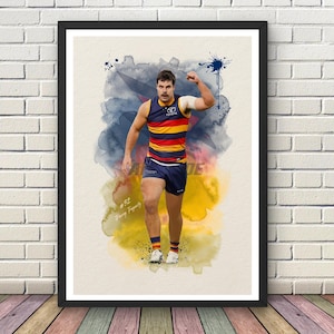 May include: A framed art print featuring a watercolour-style illustration of a football player in a navy, red, and yellow striped jersey and navy shorts. The player has one arm raised, and the text #32 Darcy Fogarty is visible in the lower left corner.