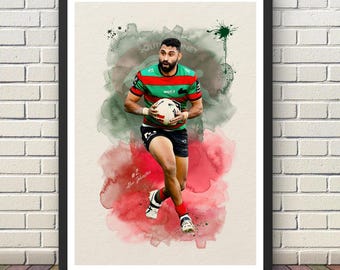 May include: A framed art print featuring a watercolor-style illustration of a rugby player in a red, green, and black jersey holding a ball. The player wears black shorts and red socks. The text #2 Alex Johnston is visible on the cream background.