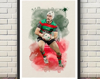May include: Watercolor print of a rugby player in a green, red, and black uniform, holding a rugby ball. The artwork features a watercolor background with green and red splashes. The player wears a helmet and is set against a white background.